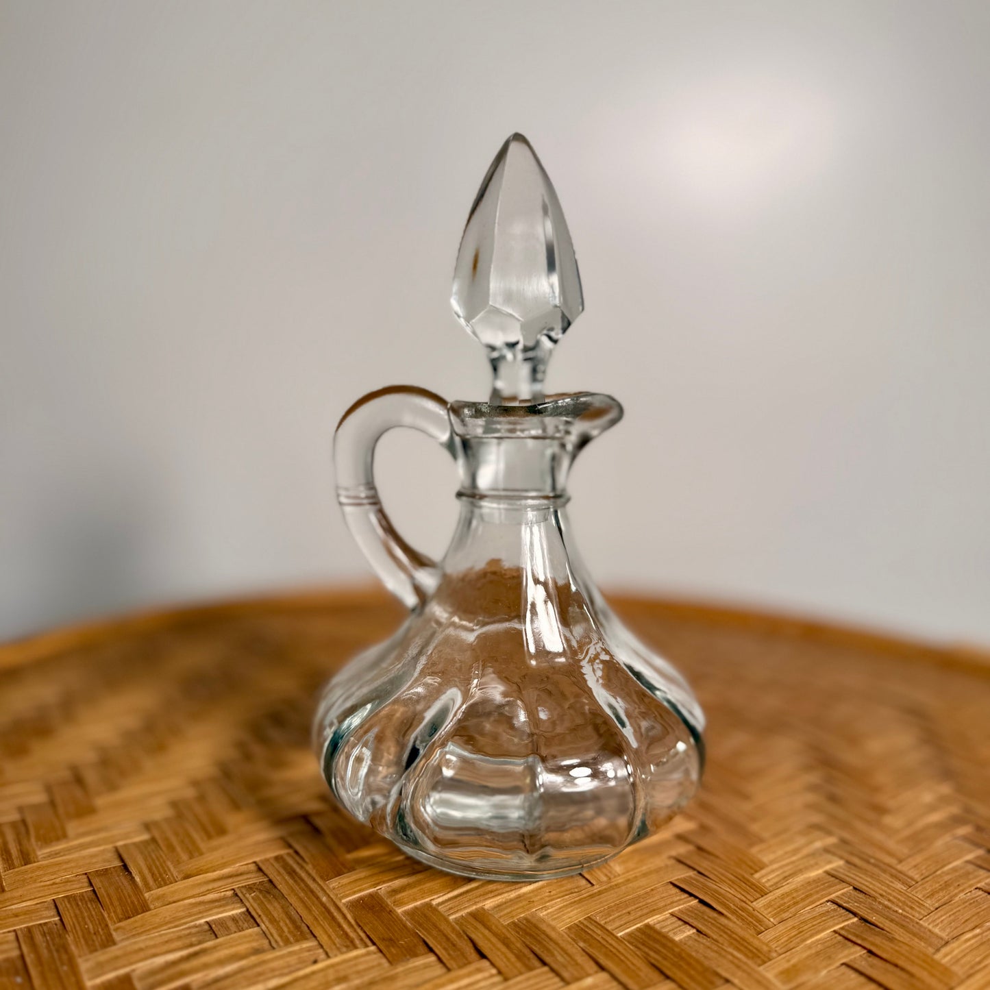 Clear pressed glass cruet with faceted stopper and rounded base, vintage Anchor Hocking
